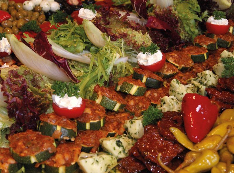 Antipasti-Platte mit Paprika, Peperoni und Salat