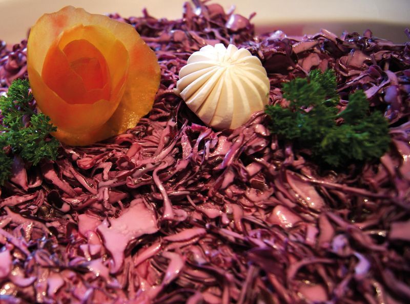 Rotkohlsalat mit einem Tupfer Sauerschmand und Möhrenrose