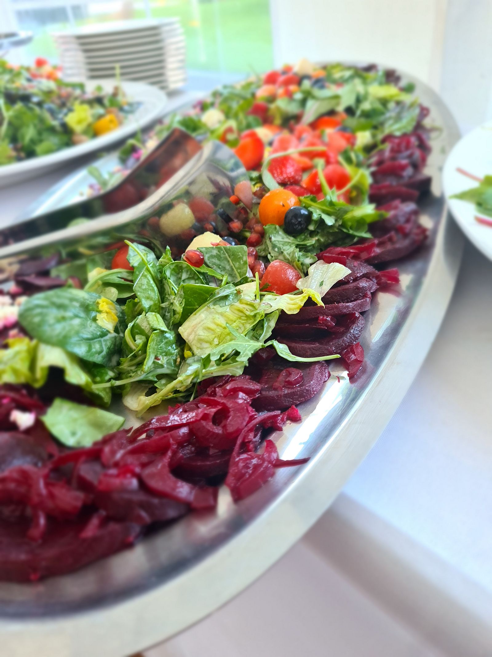 Salatplatte mit Roter Bete, Blattsalaten, Tomaten und Oliven